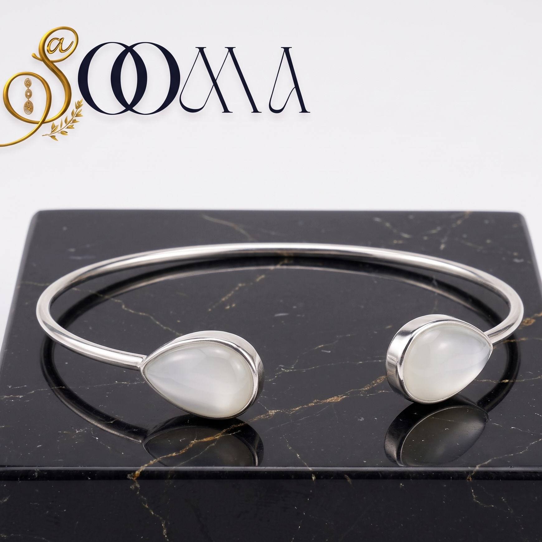 Sooma brand open cuff silver ankle kada with twin teardrop moonstone gemstones on black marble
