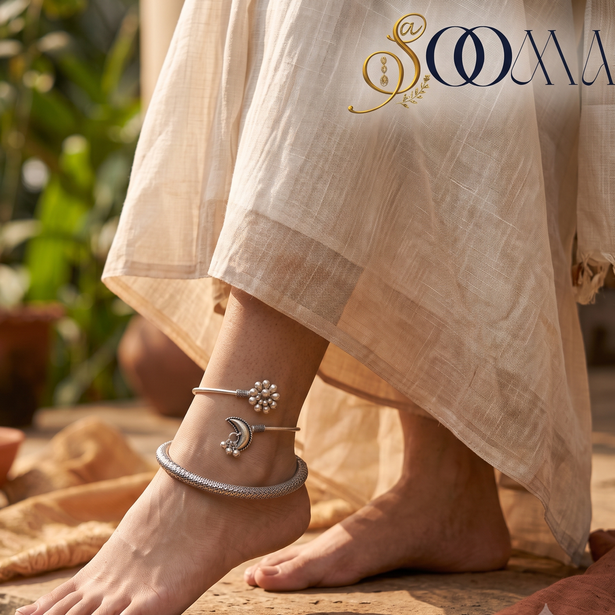 Close-up view of woman foot on stone step adorned with an oxidized silver crescent moon and flower ghungroo layered anklet stack