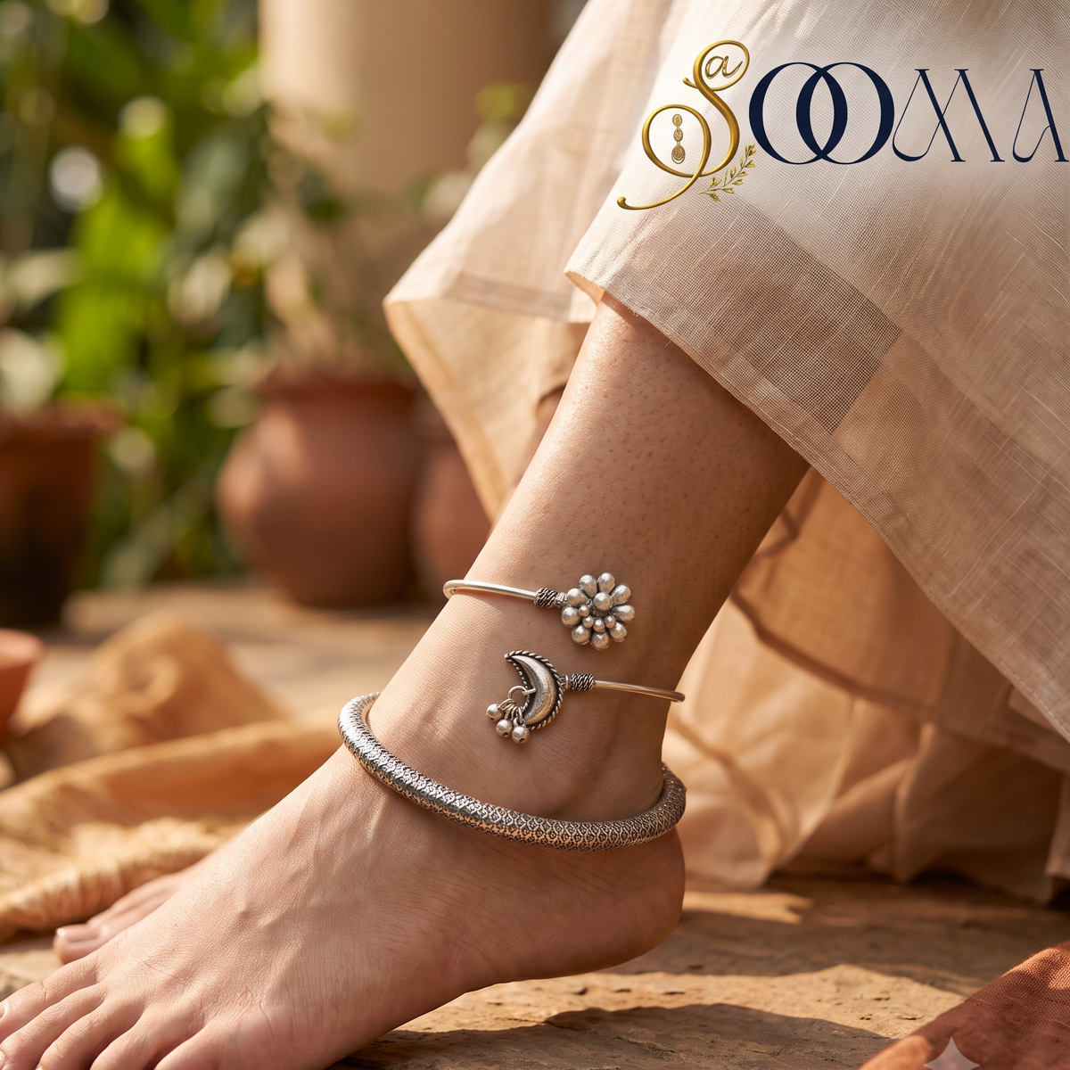 Side perspective view of model foot wearing a celestial crescent moon ghungroo bypass cuff and silver mesh HASLI kada stack paired with ivory saree