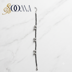 Sooma brand black seed bead anklet with silver ghungroo clusters displayed flat on white marble