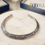 Sooma brand oxidized silver carved elephant Hasli necklace displayed flat on round white marble slab