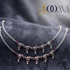 Sooma brand pair of handcrafted oxidized silver elephant motif payal anklets lying flat on plush charcoal velvet background