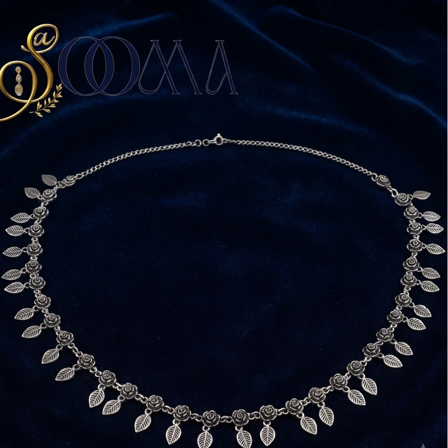 Close-up shot of the detailed floral rose motifs and leaf charms on the oxidised silver waist belt.