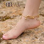 Full side view of foot showing gold floral payal with clear CZ stones and frosted ghungroo drops