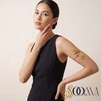 Full view of model styling a matte gold floral armlet bajuband with a sleeveless black evening dress