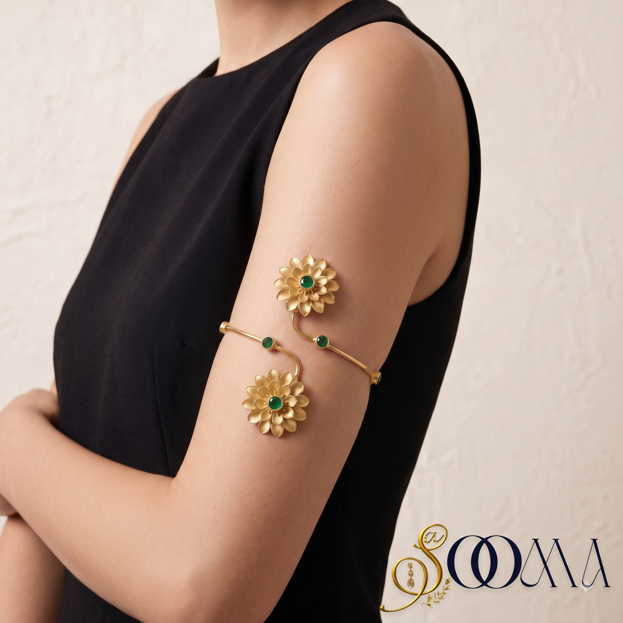 Side close-up view of model wearing matte gold floral bypass armlet with green stones on upper arm