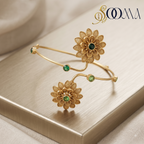 Angled detail view of handcrafted matte gold bajuband featuring dual green stone flower blooms