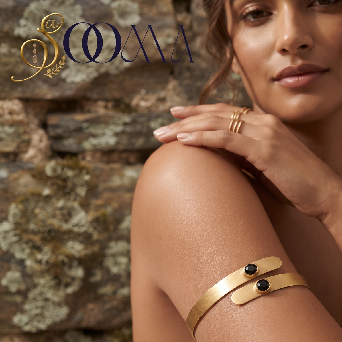 Model in neutral top wearing handcrafted matte gold bypass bajuband with black stone accent
