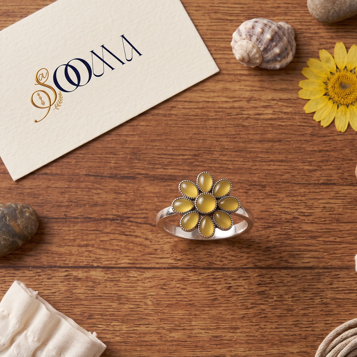 Sooma brand handcrafted oxidized silver yellow onyx 8-petal floral toe ring displayed flat on wooden surface with decorative stones