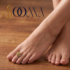 Close-up view of woman foot adorned with an 8-petal yellow onyx floral cluster toe ring on velvet cushion