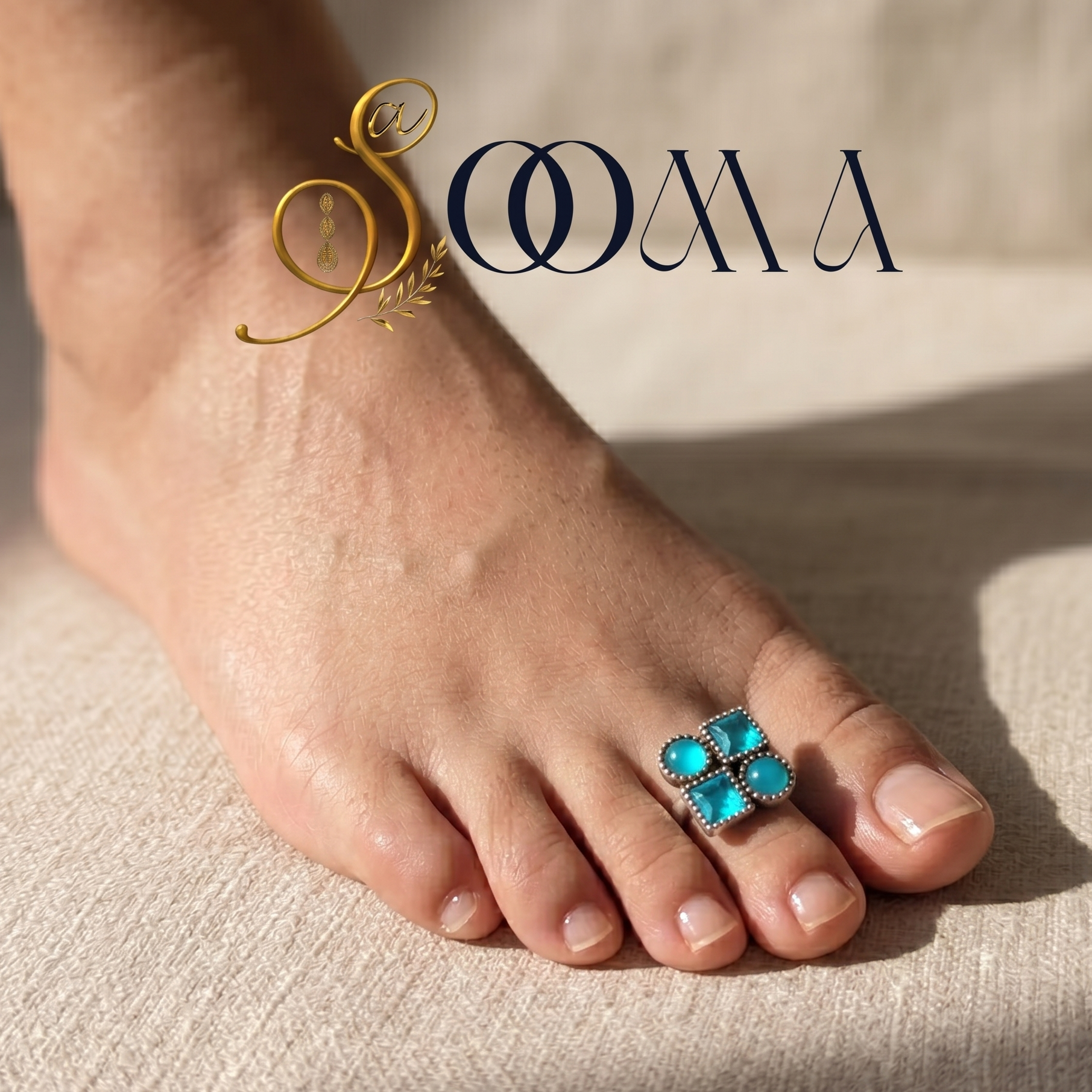 Foot wearing a turquoise toe ring with 'Sooma' branding.