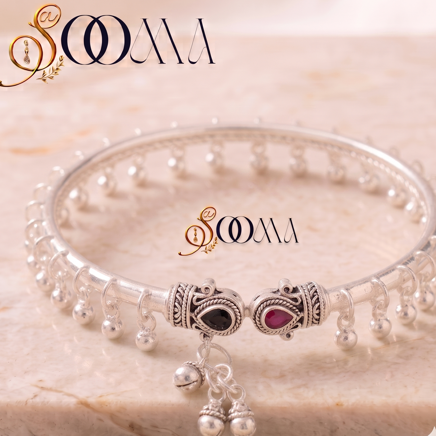 Sooma brand silver ghungroo ankle kada with dual stone elephant terminals displayed flat on marble