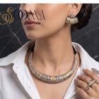 Model in white linen shirt wearing dual-tone oxidized silver and gold carved Hasli necklace set with matching earrings