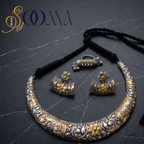 Sooma brand dual-tone oxidized silver carved Hasli necklace set, floral studs, and ghungroo ring flat lay on dark marble
