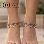 Model wearing traditional peacock link ghungroo payal anklets outdoors on a stone background