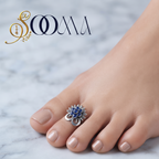 Front view of model feet with nude nail polish wearing an oxidized silver royal blue stone sunburst toe ring on marble floor