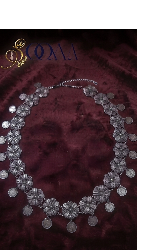 Sooma brand oxidized silver filigree floral and coin drop waistband displayed flat on dark background with ceramic display