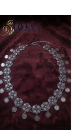 Sooma brand oxidized silver filigree floral and coin drop waistband displayed flat on dark background with ceramic display