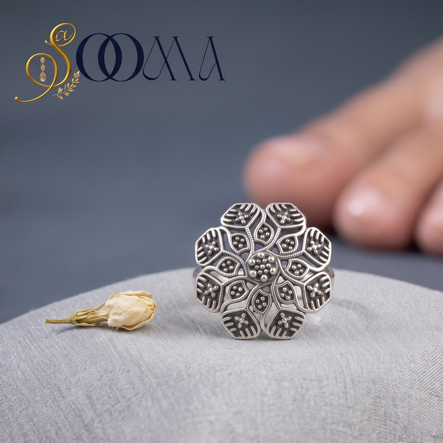 Macro close-up shot of Sooma brand oxidized silver mandala floral toe ring displayed on grey silk