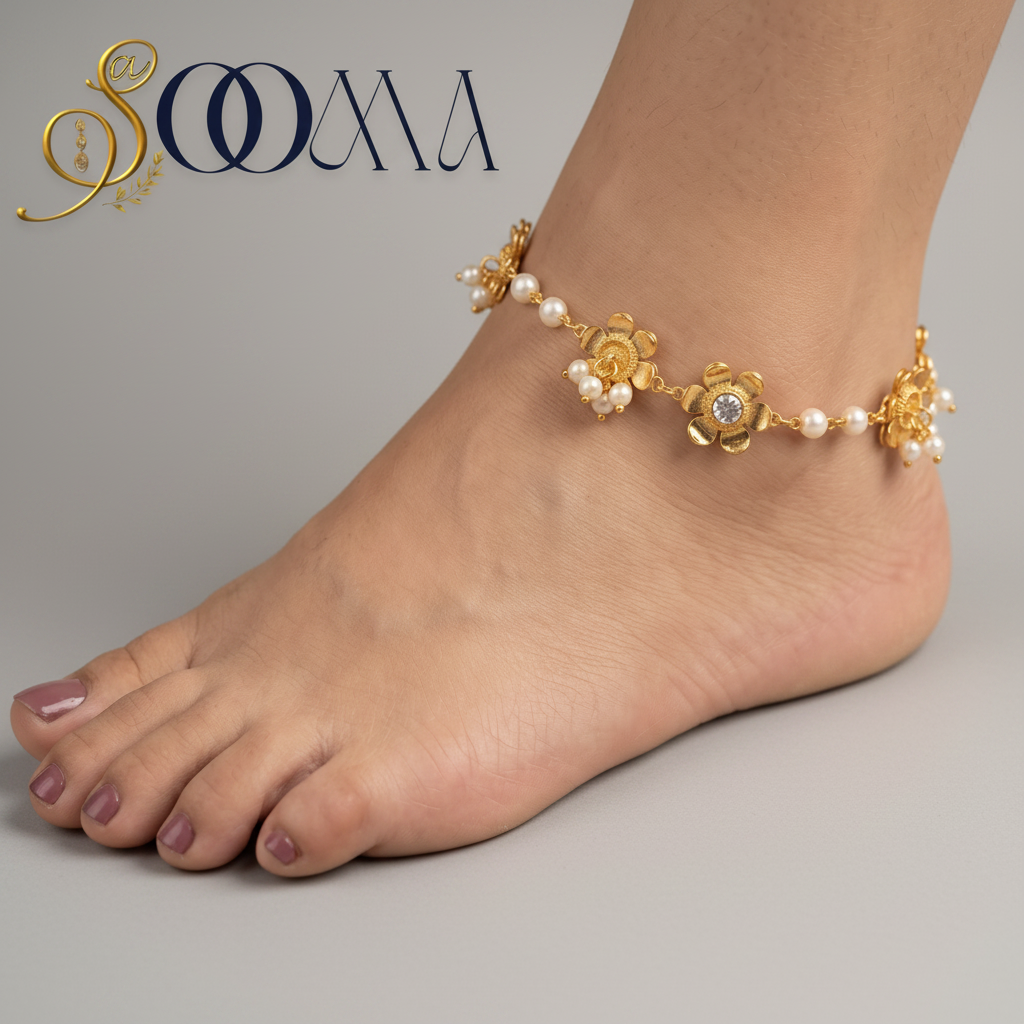 A gold-toned floral anklet with small white pearl-like beads worn on a person's ankle, shown resting on a wooden surface with a neutral fabric background. The brand name SOOMA appears in the upper left.