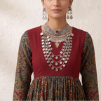 Model in maroon printed Anarkali dress wearing heavy oxidized silver ruby tribal choker and 4-tier coin necklace stack