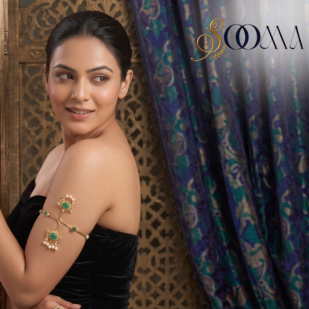 Close-up view of arm showing gold bypass bajuband with green stone and pearl drops