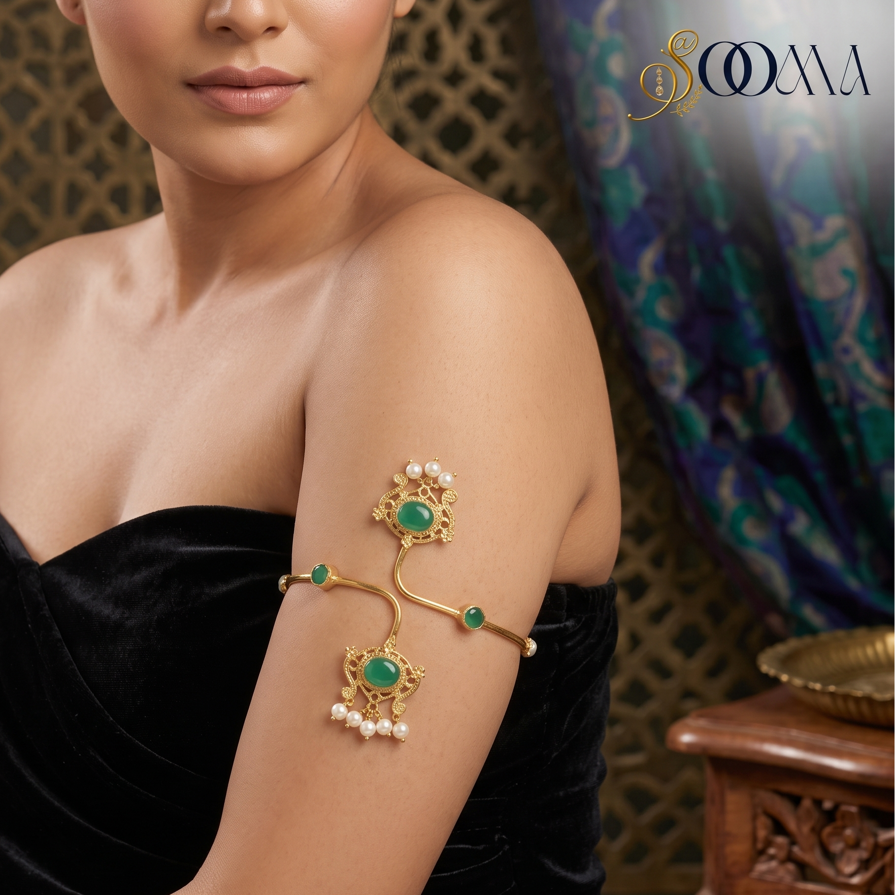 Model in black dress wearing regal gold emerald and pearl armlet bajuband