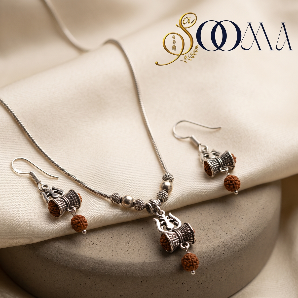 Sooma brand silver Trishul Damru pendant necklace with natural Rudraksha beads and matching drop earrings on satin display