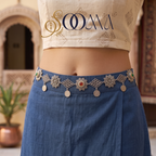 Front view of oxidized silver kamarbandh with ruby emerald stones and hanging coin charms on blue skirt