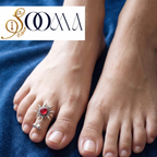 lose-up top view of model toe wearing an adjustable oxidized silver solar ray toe ring with a faceted red stone and ghungroos