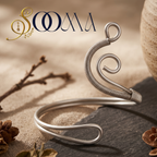 Sooma brand flat lay view of handcrafted wire-wrapped spiral wave oxidized silver ankle cuff on dark stone slab