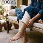 Full lifestyle portrait of model on woven charpoy showing the high-ankle fit of the wire-wrapped spiral wave silver cuff