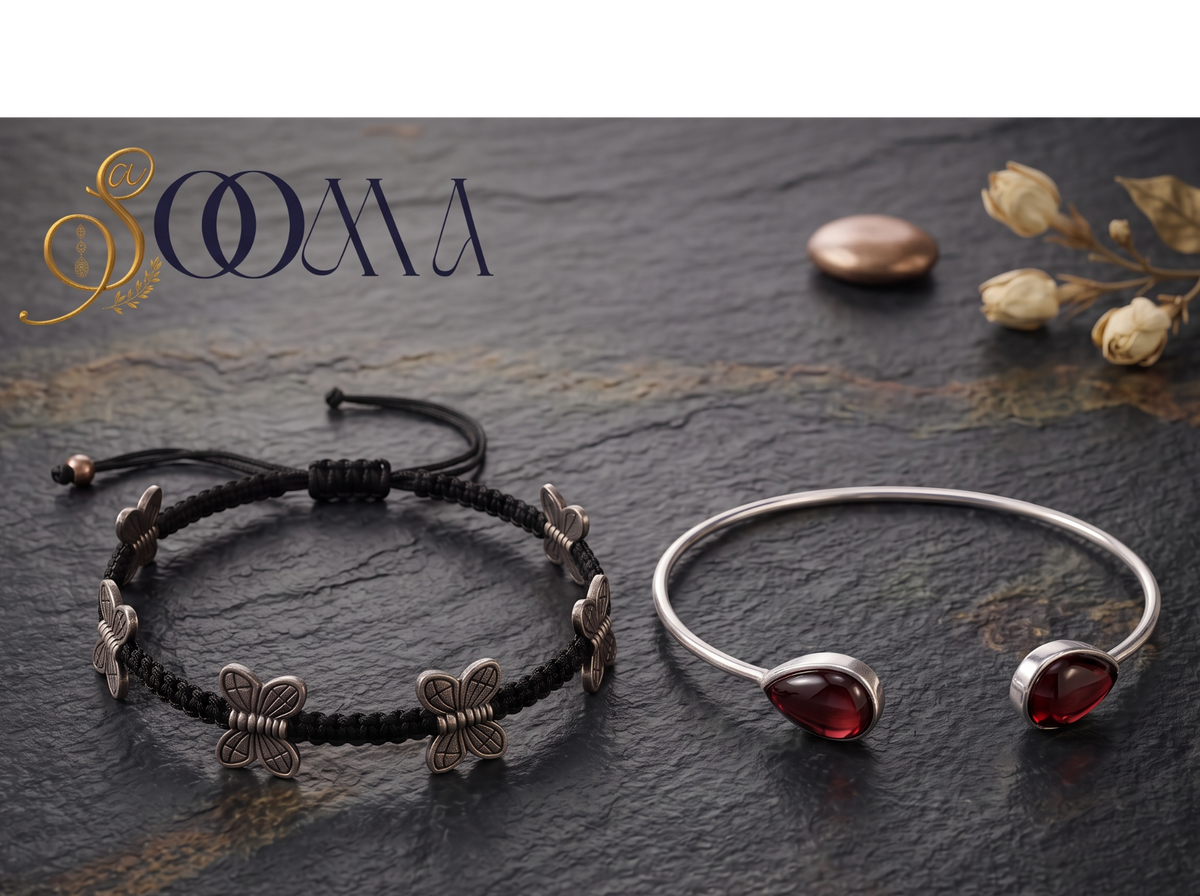 ooma brand display banner showing 2-piece ankle stack with black macrame butterfly cord and teardrop garnet bypass cuff flat lay on dark stone