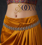 Front view close-up showing oxidized silver textured butterfly link waist chain cinching mustard yellow draped skirt