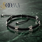 Close-up view of adjustable black thread anklet with silver butterfly charms on ankle