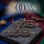 ooma brand pair of handcrafted oxidized silver Trishul Om arrow non-piercing bugadi ear cuffs displayed on black stone block