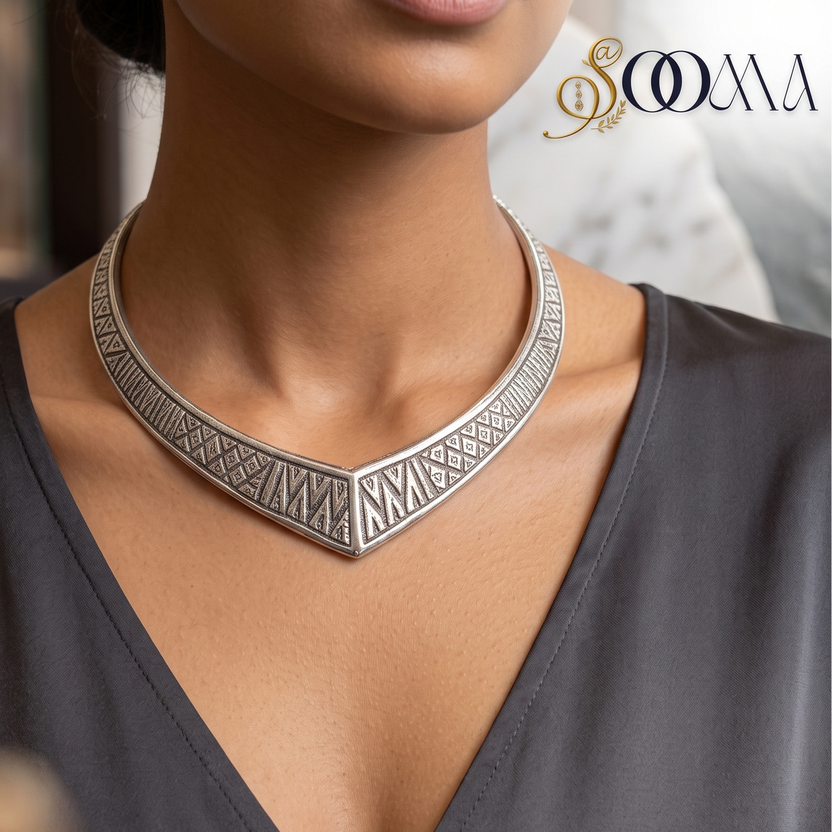 Model in grey V-neck blouse wearing handcrafted oxidized silver geometric V-neck Hasli choker