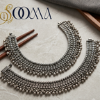 Flat lay shot of Sooma broad oxidized silver tribal payal anklets pair with ghungroo fringe on marble surface