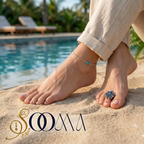 Feet with anklets and a ring by a poolside, featuring the brand 'Sooma'.