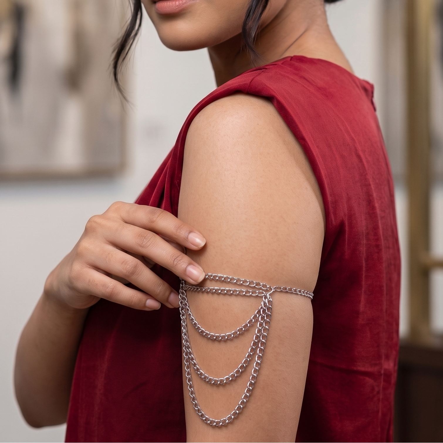Model wearing a polished silver layered curb chain armlet with cascading draped chains on upper arm