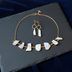 Gold natural stone necklace and earrings  on a dark surface
