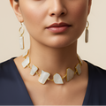 Woman wearing a gold uncut stone necklace and earrings 