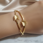 Close-up of a wearing  a Gold Butterfly Cuff Bracelet showcasing the detailed butterfly design and polished gold finish. 