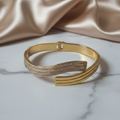 Close-up of a gold-plated bracelet with a secure clasp, showcasing its radiant finish and sleek design.