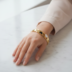 Elegant heart bracelet on a woman's wrist, suitable for professional attire.