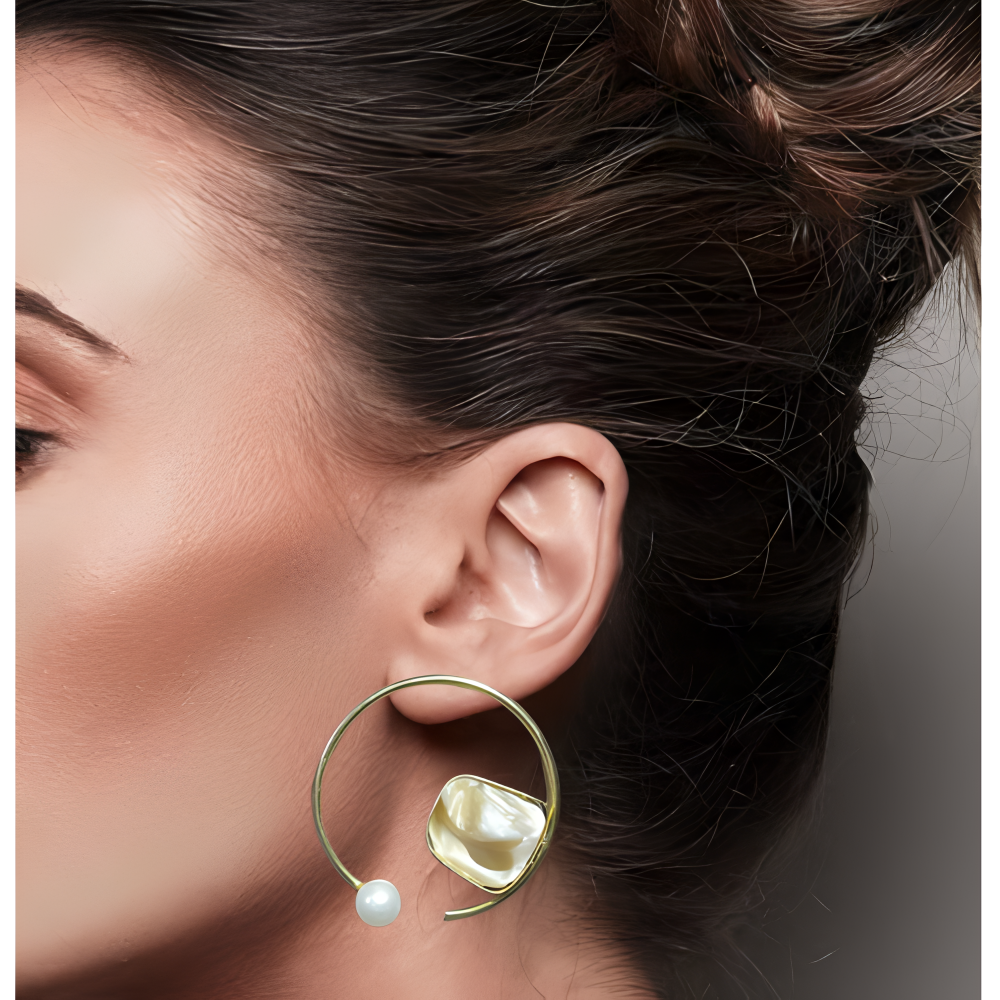Close-up of a model wearing a gold stud earring with a pearl accent.