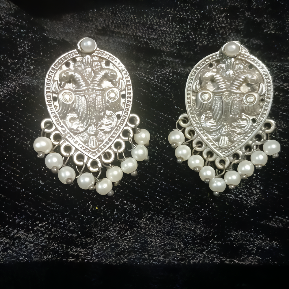 Pair of intricately crafted silver earrings with beads