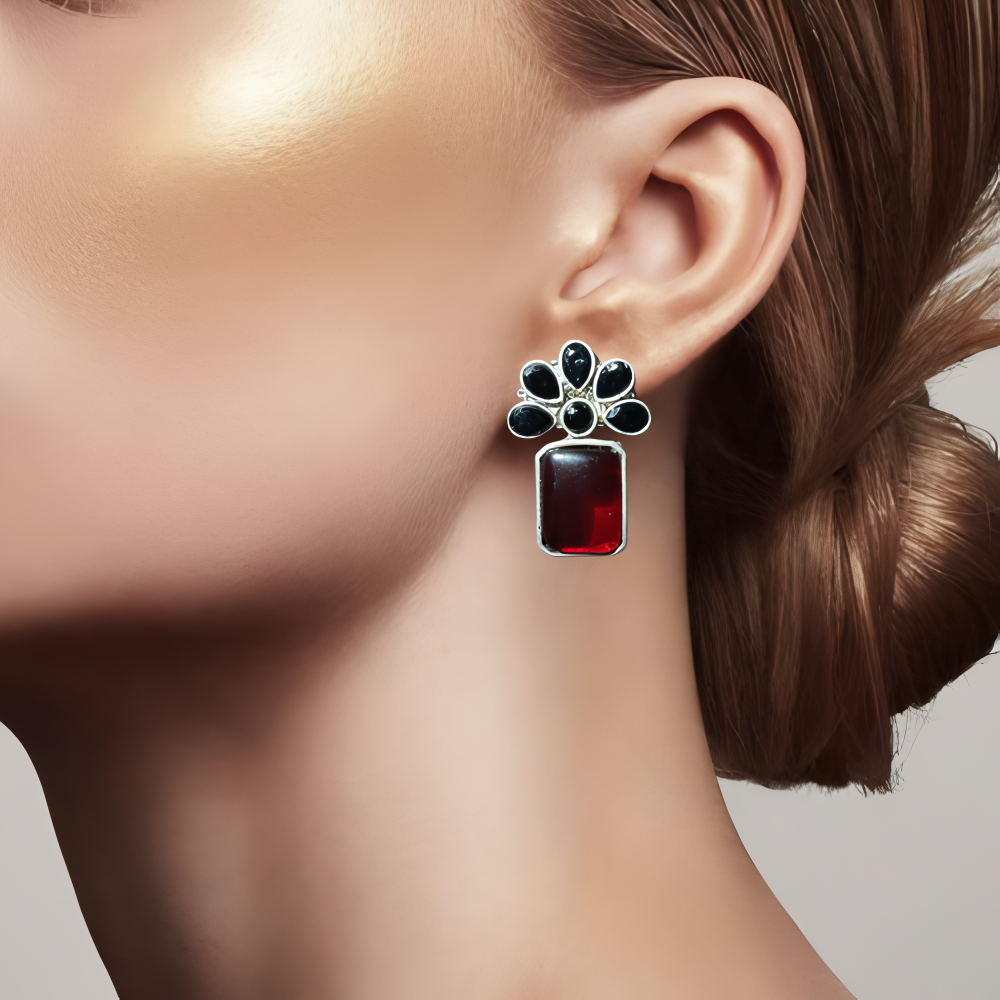Close up of an elegant lady wearing a red & black stone earrings in floral design .