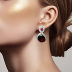 Close-up of a woman wearing an oxidised silver earring with red and pink gemstones. 