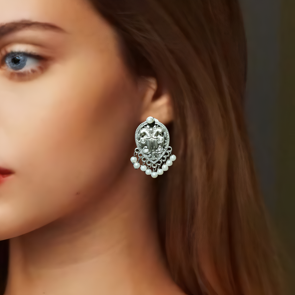 Close-up of a lady wearing an silver stud earring with pearls.